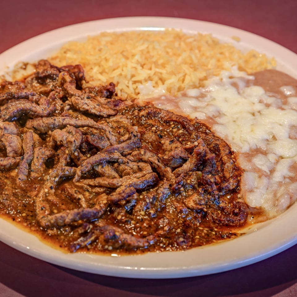 Casa Mexicana's carne asada with rice and refried beans, topped with melted cheese.